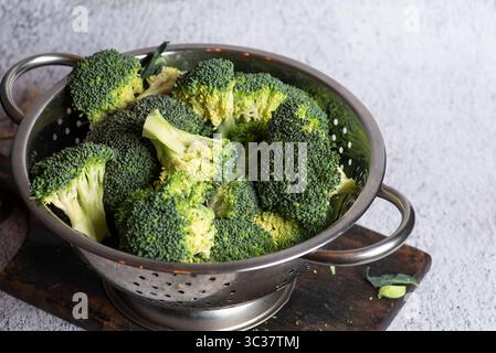 Eine lebendige Präsentation frisch geernteter Brokkoli-Röschen auf einem rustikalen Schneidebrett, inspiriert für kreative Kochideen oder gesunde Speisen Stockfoto