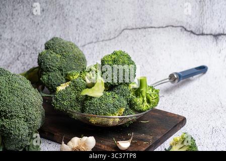 Eine lebendige Präsentation frisch geernteter Brokkoli-Röschen auf einem rustikalen Schneidebrett, inspiriert für kreative Kochideen oder gesunde Speisen Stockfoto