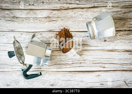 Explodierende Moktopf-Szene: Eine offene Brauerei, eine Filtertasse, die frisches Wasser verschüttet, verstreute Bohnen und Gewürze auf rustikalem Holz erinnern an den handwerklichen Kaffee-Flair Stockfoto