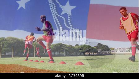 Beim Training mit hohen Knien über orangefarbenen Kegeln, beim Training männlicher Fußballspieler auf dem Parkfeld, mit Lätzchen Stockfoto