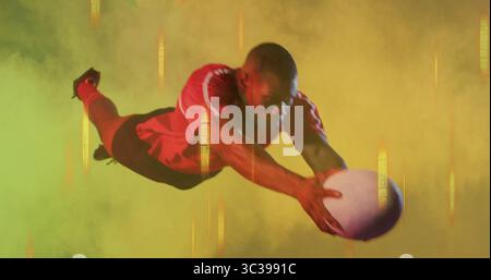 Tauchsportler, der im Studio weißen Ball anfängt, rotes Jersey, schwarze Shorts, Stollen und farbigen Nebel trägt Stockfoto