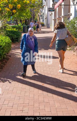 Ältere behinderte Moslim-Frau, die in Santa Barbara, Kalifornien, in die Innenstadt läuft. Stockfoto