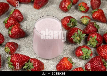 Süßer Erdbeermilchshake im Glas unter frischen Reifen Erdbeeren Stockfoto