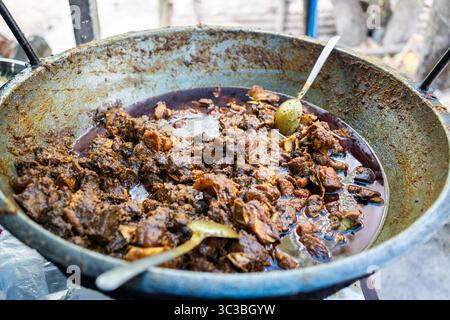 Eine lebhafte Auswahl an verschiedenen Bangladeschen Currys und Gerichten auf einer farbenfrohen Tischdecke, wahrscheinlich in einem Street Food Stall oder einem lokalen Restaurant in Dhaka. Stockfoto