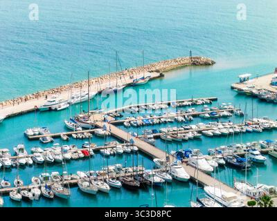 Aus der Vogelperspektive des Yachthafens in Sidi Bou Said, Tunesien, mit Yachten, Segelbooten und türkisfarbenem Wasser entlang der Mittelmeerküste. Stockfoto