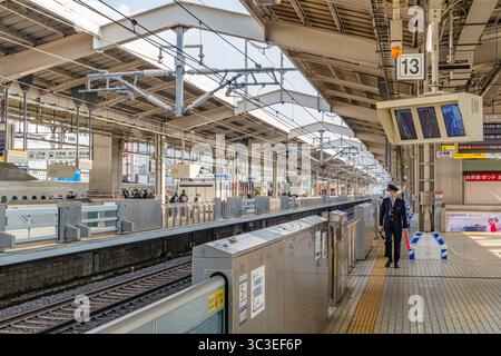 Tokio, Japan - 15. Januar 2025 Eisenbahnarbeiter in Uniform wartet auf Shinkansen-Hochgeschwindigkeitszug im Bahnhof. Stockfoto