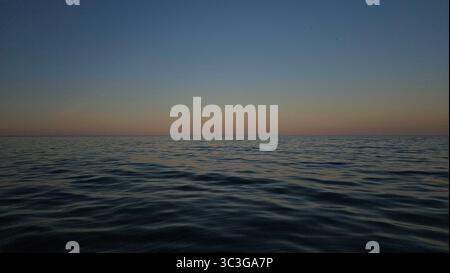 Ruhiger Sonnenuntergang über ruhigem Meer Wasser Sonnenuntergang über dem Meer Stockfoto