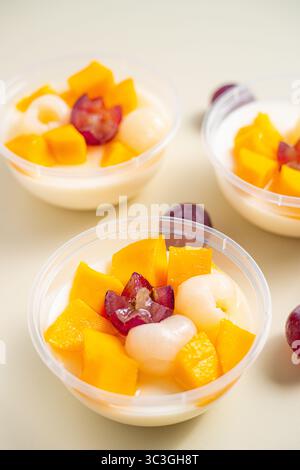 Drei Schüsseln Puddingfrucht mit einer blumigen Form von Traube oben. Die Schüsseln sind mit Obst gefüllt und die Früchte sind so angeordnet, dass sie aussehen Stockfoto