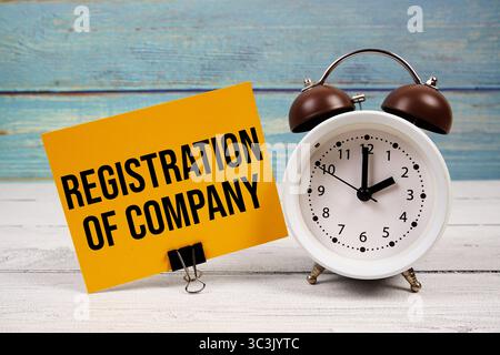 Text zur Registrierung des Unternehmens (ROC) auf Papierkarte mit Wecker auf hölzernem Hintergrund geschrieben Stockfoto