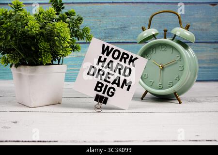 Work Hard Dream großer Text auf Papierkarte mit Wecker auf hölzernem Hintergrund geschrieben Stockfoto