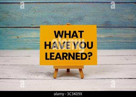 Was Haben Sie Gelernt? Text auf Papierkarte auf hölzernem Hintergrund geschrieben Stockfoto