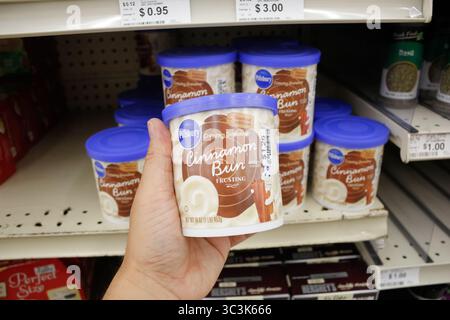 Los Angeles, Kalifornien, USA - 02-12-2020: Ein Blick auf eine Hand, die einen Behälter mit Pillsbury Creamy Supreme Cinnamon Bun Frosting hält. Stockfoto