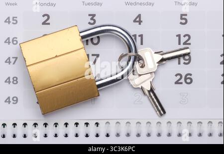 Schließen Sie das Schloss mit den Schlüsseln auf dem Kalender in Nahaufnahme Stockfoto