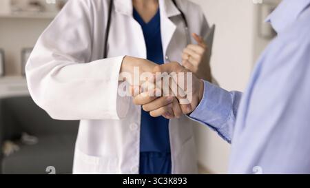 Hausarzt schüttelt mit männlichem Patienten die Hand Stockfoto