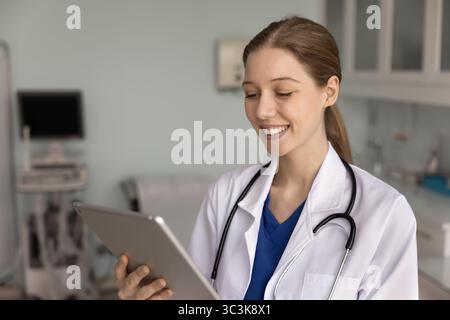 Positive erfolgreiche Ärztin, die Aufzeichnungen liest Stockfoto