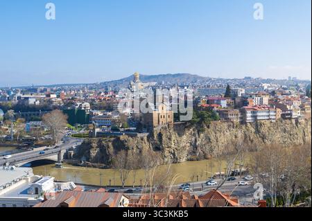 Ein atemberaubender Panoramablick fängt das pulsierende Stadtbild von Tiflis, Georgien, unter einem hellen, klaren Himmel ein. Die historische Architektur und moderne Bauten Stockfoto