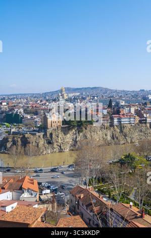 Ein atemberaubender Panoramablick fängt das pulsierende Stadtbild von Tiflis, Georgien, unter einem hellen, klaren Himmel ein. Die historische Architektur und moderne Bauten Stockfoto