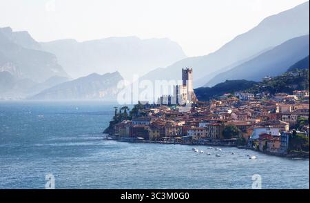 Stimmungsvoller Blick auf das Schloss Scaliger im Dorf Malcesine auf der Ostseite des Gardasees in Italien mit Bergkulisse dahinter Stockfoto