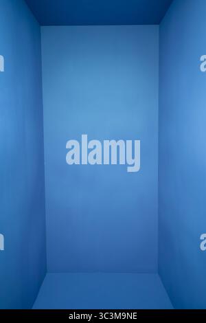 Ein minimalistischer blauer Raum mit sanfter Beleuchtung und Kopierraum für Text und Designs Stockfoto