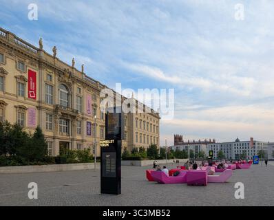Berlin, Deutschland. Juli 2025. Die Menschen sitzen am 20. Juli 2025 auf modernen pinkfarbenen Bänken vor dem Humboldt-Forum im rekonstruierten Berliner Schloss in Berlin. Das Humboldt Forum ist ein bedeutendes Museum und Kulturzentrum im Herzen Berlins und ein beliebtes Ziel für Touristen und Einheimische. (Foto: Michael Nguyen/NurPhoto)0 Credit: NurPhoto SRL/Alamy Live News Stockfoto