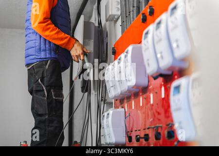 Ein Techniker installiert Komponenten des Solarmodulsystems, wobei er sich auf den Anschluss der elektrischen Verkabelung konzentriert. Das Bild zeigt die für erforderliche technische Expertise Stockfoto
