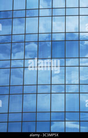 Ein beeindruckendes Bild moderner Architektur, das die reflektierende Glasfassade eines Gebäudes zeigt und das Wesen von zeitgenössischem Design und urbanem Bau festlegt Stockfoto