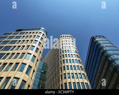Von unten fängt die Niedrigwinkelaufnahme moderne Moskauer Wolkenkratzer mit reflektierenden Glasfassaden vor einem klaren blauen Himmel ein und betont ihre Architektur Stockfoto