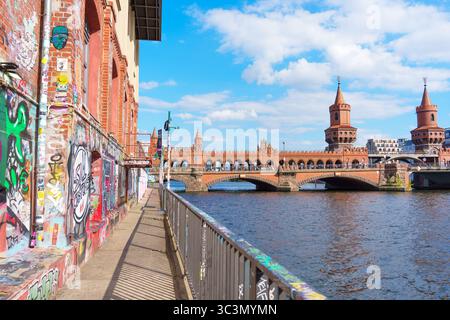 Berlin, Deutschland - 30. Mai 2025: Oberbaumbrücke mit lebhaften Graffiti-Mauern entlang der Spree an einem klaren Tag mit blauem Himmel und urbaner Szene Stockfoto