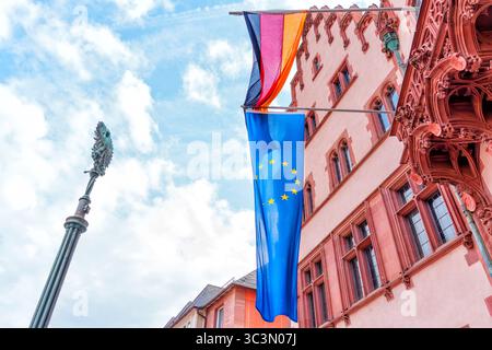 Frankfurt, Deutschland - 10. Juni 2025: Fahnen von Deutschland und der Europäischen Union flattern auf einem historischen Gebäude in Frankfurt, leuchtende Farben gegen eine p Stockfoto