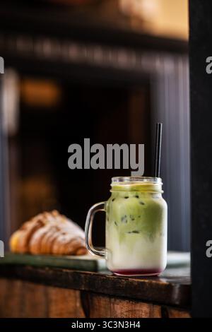 Erfrischender Matcha-Latte mit köstlichem Croissant. Perfekt für einen entspannenden Urlaub. Stockfoto
