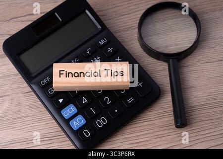 Text für Finanztipps auf Holzblock oben auf dem Rechner Stockfoto