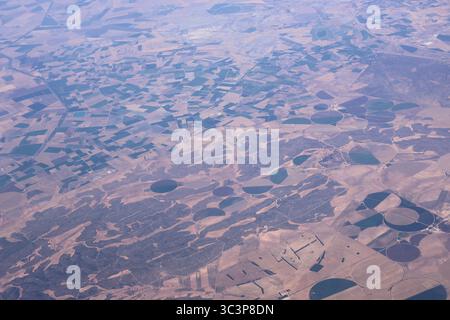 Luftaufnahme landwirtschaftlicher Felder und kreisförmiger Bewässerungssysteme in der ländlichen Landschaft. Eine Höhenperspektive mit einem Flickenteppich von Stockfoto