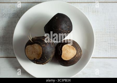 Eine Ansicht von oben nach unten von einigen schwarzen Radieschen auf einem Teller. Stockfoto
