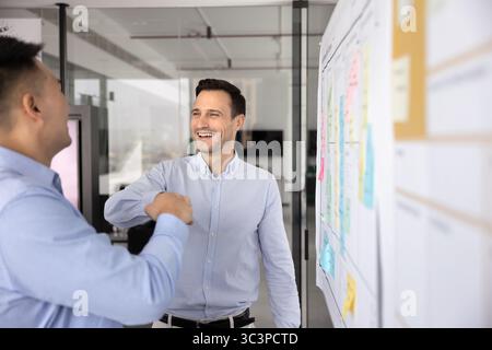 Zwei glückliche Männer Kollegen Fäuste schlagen im Büro Stockfoto
