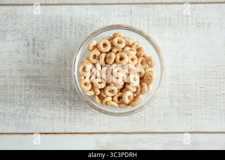 Ein Blick von oben nach unten auf getoastetes O's Müsli in einer kleinen Glasschale. Stockfoto