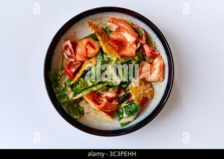 Köstlicher gemischter Salat mit frischem Gemüse, saftigen Tomaten, knusprigen Croutons und cremigem Dressing in einer wunderschönen Schüssel Stockfoto