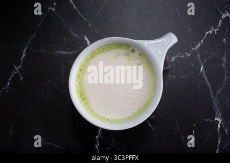 Von oben auf einen Matcha Latte Becher. Stockfoto