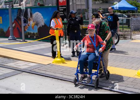 San Diego, Kalifornien, USA. Juli 2025. Während der Comic-Con 2025 überquert ein älteres Paar die Trolley-Gleise in der Nähe des San Diego Convention Center. Während der Comic-Con 2025 versammelten sich Fans vor dem San Diego Convention Center und verwandelten die umliegenden Straßen in eine lebendige Feier der Popkultur. Obwohl es keine offiziellen Abzeichen gab, nahmen sowohl Teilnehmer als auch Touristen an immersiven Markenaktivierungen, Cosplay-Meetups, von Fans gemachten Auftritten und Outdoor-Werbeveranstaltungen Teil. Diese Serie fängt den dynamischen und inklusiven Geist der Comic-Con jenseits der offiziellen Mauern ein Stockfoto