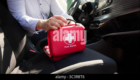 Männlicher Mediziner Verstaut Erste-Hilfe-Zubehör In Der Handschuhbox Stockfoto