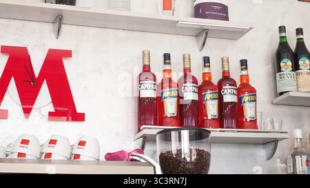 Cremona, Italien - 26. Juli 2025 Eine gut organisierte Bar zeigt eine Auswahl an farbenfrohen alkoholischen Getränken in Glasflaschen neben einem Kaffee Stockfoto