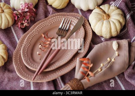 Elegante Thanksgiving-Tischdekoration mit Kürbissen und rustikaler Einrichtung Stockfoto