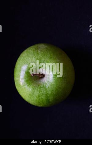 Frischer grüner Apfel auf dunklem Hintergrund in Nahaufnahme Stockfoto
