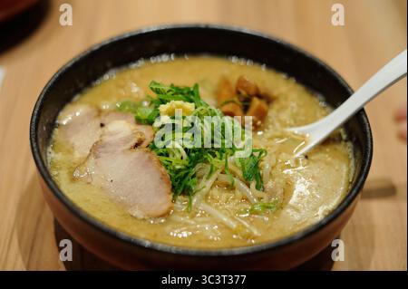 Traditionelle köstliche Ramen-Nudelsuppe in einer Schüssel mit Miso-Paste, Fleisch, Algen und Zwiebeln in Japan Stockfoto