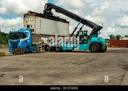 Lkw, der einen Kühlcontainer für den weltweiten Transport frischer Produkte liefert, bereit für eine neue Fracht auf dem Fruit Warf Terminal & Docks in Merwe Harbour, Rotterdam, Niederlande. Stockfoto