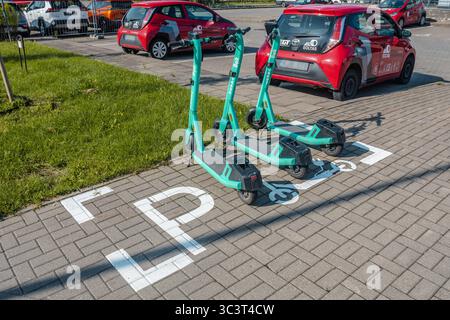 Elektroroller parken am ausgewiesenen Rollerparkplatz auf dem Bürgersteig der Stadt Stockfoto