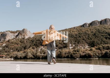 Frau in gelber Jacke genießt die Aussicht Stockfoto