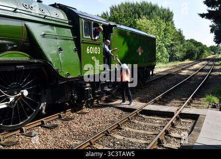 Die Flying Scotsman Dampflokomotive Feuerwehrmann und der Hampton Loade Signalgeber tauschen ihre Instrumente aus, wenn der Zug durch den Bahnhof Hampton Loade fährt Stockfoto
