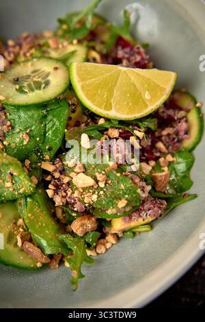 Lebendiger und nahrhafter gemischter Salat mit frischen Gurken, Quinoa, Limette und Crunchy Nüssen, perfekt für eine gesunde Mahlzeit oder Beilage Stockfoto