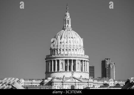 Die berühmte Kuppel der St. Paul's Cathedral erhebt sich majestätisch über einem klaren Himmel und zeigt ihre architektonische Schönheit. Die umliegenden Gebäude stehen im Kontrast zu ihrer historischen Eleganz. Stockfoto