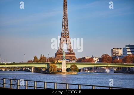 Eiffelturm über die seine mit Grenelle-Brücke und Freiheitsstatue an einem hellen Herbsttag in Paris, Frankreich Stockfoto